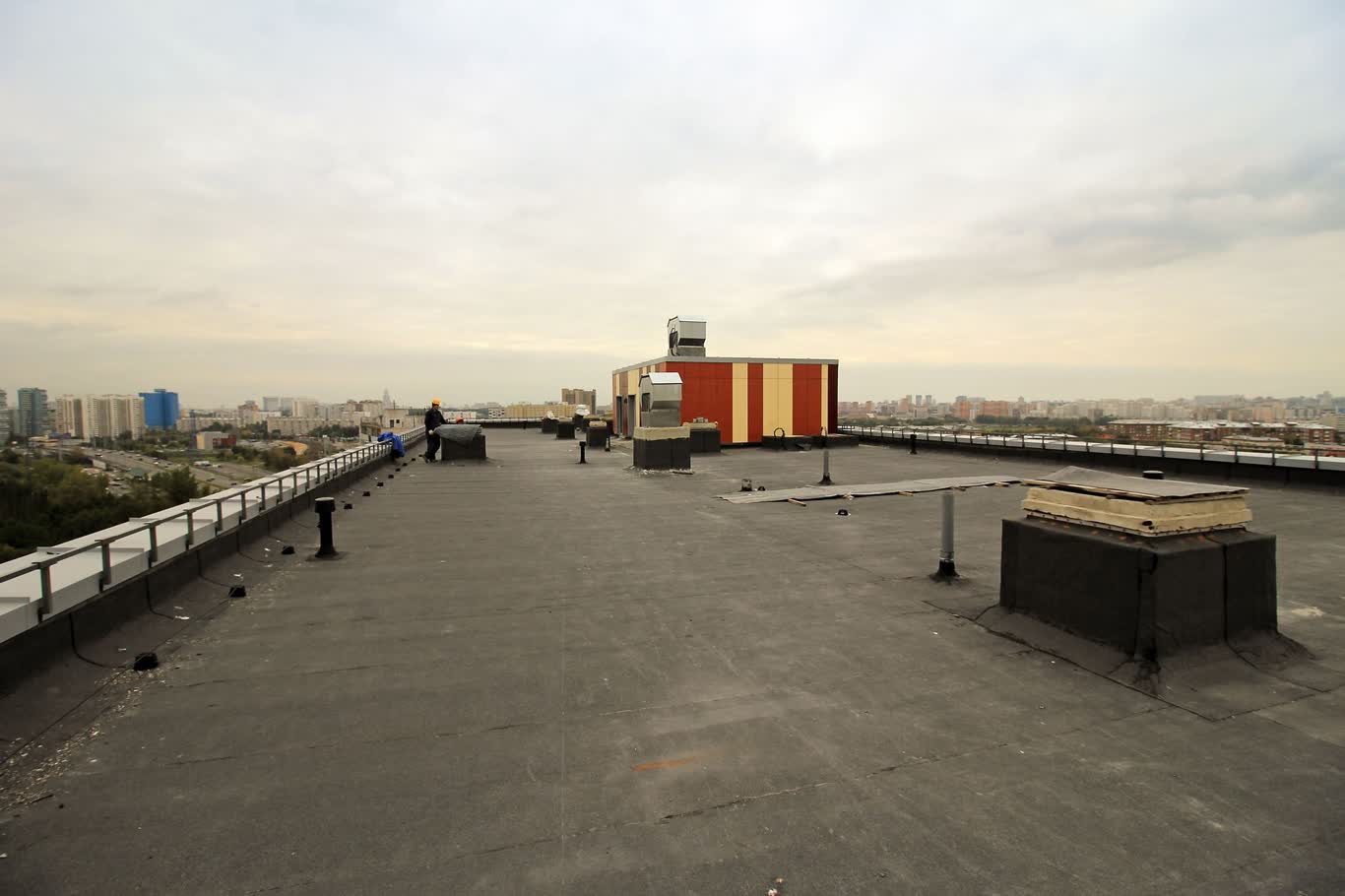 Modified bitumen hot-mop roofing installation showing layered membrane process